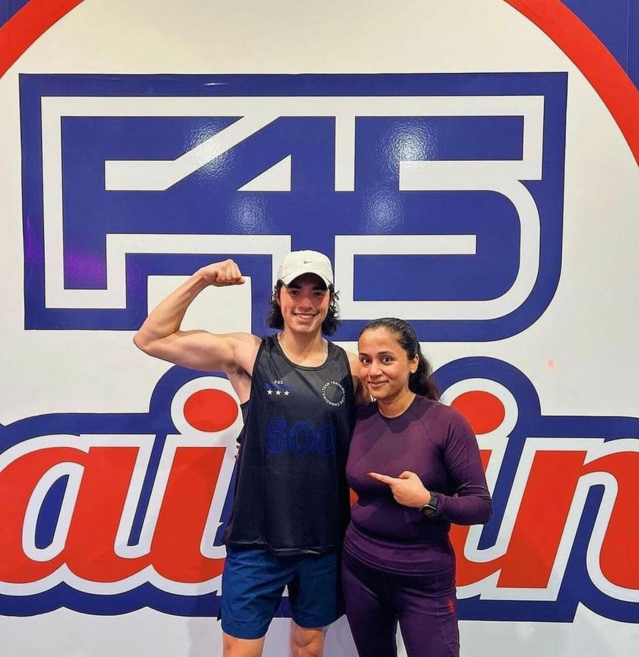 F45 member result story in front of the logo wall